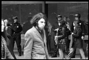 Police watch as antiwar demonstrators picket in front of the John F. Kennedy Federal Building