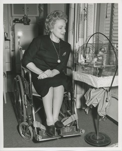 Mrs. Frances Marsala seated in her wheelchair admiring her birdcage