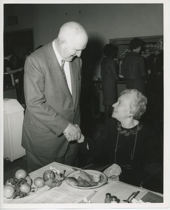 Unidentified man and woman shaking hands at Thanksgiving celebration