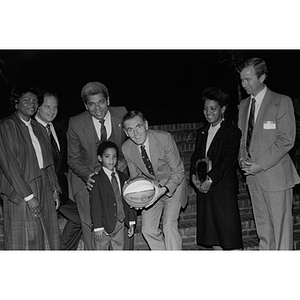 Mayor Raymond Flynn holds a basketball and poses with a group of people, including Carmen Pola