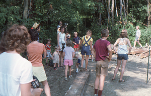 Anne Skinner (camera around neck), Hank Flynt (in rear with 16mm movie camera) and crowd at Moon Barn Raising at entrance to Hopkins Forest on 2 August 1975.