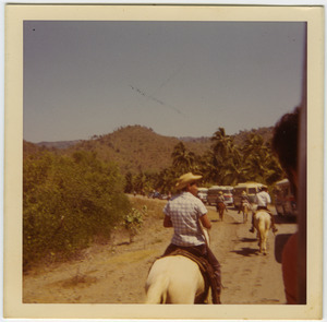Campesinos on horseback riding past Brigade buses