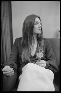 Judy Collins: three-quarter length portrait,seated in a chair with spray of flowers