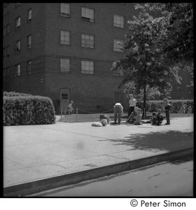 Children playing on the sidewalk in front of a Riverdale apartment building