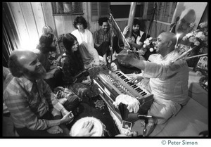 Amazing Grace members seated around an Indian harmonium player, Ram Dass seated directly in front