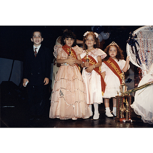 A boy in a suit stands with three girls in dresses at the Festival Puertorriqueño