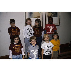 Young children posing for a group photograph wearing Waltham YMCA shirts