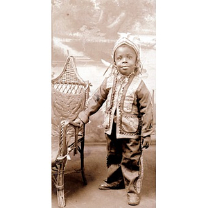 A young African American boy with a chair