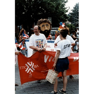 David Cortiella holding up one end of a red banner during the 1998 Festival Betances parade.