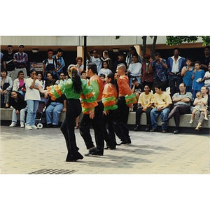 Four dancers performing in a line in the plaza for Festival Betances spectators.