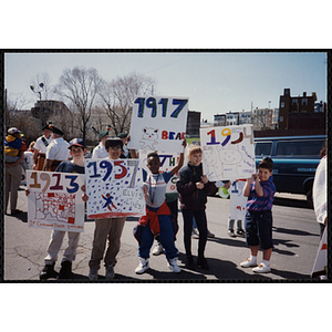 Three boys and a girl pose with their signs during the Boys and Girls Clubs of Boston 100th Anniversary Celebration Parade