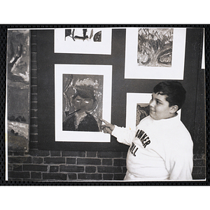 Charlestown Boys' Club member Joseph Craven points to his entry in the Boys' Clubs of Boston Tri-Club Art Exhibit at the Museum of Science