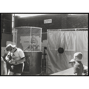 Boys stand near a dunk tank at a carnival