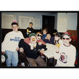 Group of children posing for camera and wearing funny glasses and hats