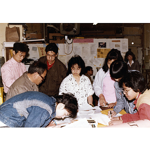 Community volunteers at the Chinese Progressive Association headquarters look at the signatures collected on behalf of Long Guang Huang