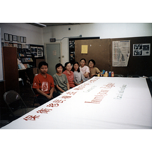 Seated people with a protest banner