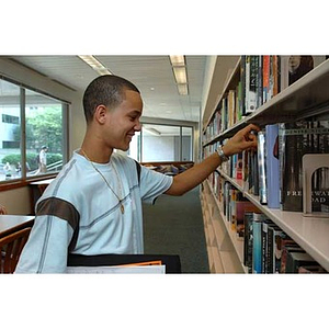 Odalis Polanco looks at books during the Torch Scholars Scavenger Hunt