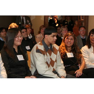 Three Torch Scholars sit in the audience at a Torch Scholars event