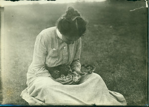 Woman cradling ducklings, undated