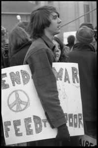 Protester at the Counter-inaugural demonstrations, 1969, against the War in Vietnam, carrying a signed reading 'End war, feed the poor'