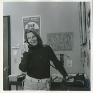 Joan P. Bean standing indoors, talking on the phone