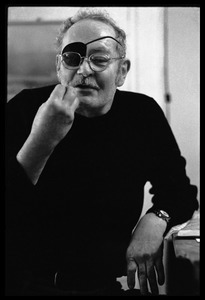 W. Eugene Smith, seated at a desk in his home