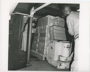 Unidentified men loading boxes onto a truck