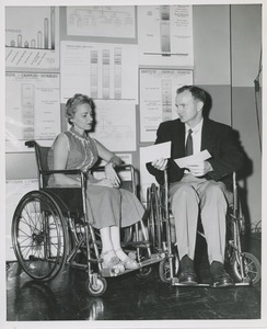 Woman and man in wheelchairs in conversation at an administrators training group