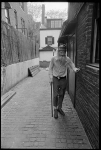 Prescott Townsend walking with a cane up a Beacon Hill alley