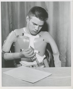 William Anderson holding a pencil with his prosthetic arm