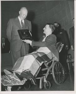 President Dwight D. Eisenhower presenting a plaque to an unidentified man in a wheelchair