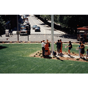 Several people gather around a flag pole