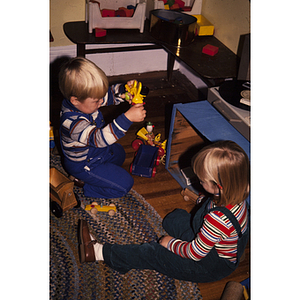 Young children sitting on the floor playing with toys