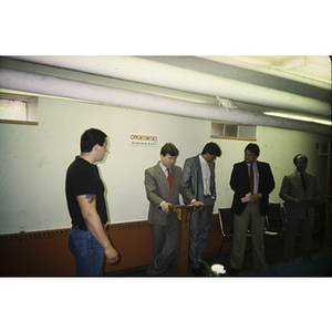 Men in suits standing at the front of a room