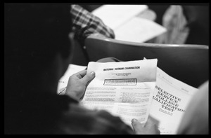 Students looking over the instructions for the 'National Vietnam Examination' (the Selective Service College Qualification examination) to determine eligibility for educational deferments from service in the Vietnam War