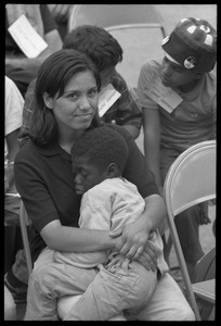 White woman in the Solidarity Day crowd at the Poor People's March on Washington, hugging an African American child while Coretta Scott King speaks