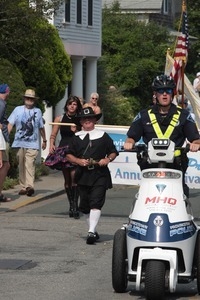 Police and man dressed in a Puritan costume leading the parade : Provincetown Carnival parade