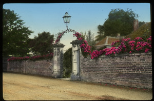 The Close, Salisbury, England (brick wall covered in pink flowers, decorative entrance archway with lamp)