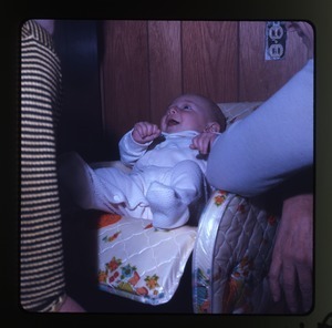 Baby (Eben) in baby seat, laughing, Montague Farm Commune