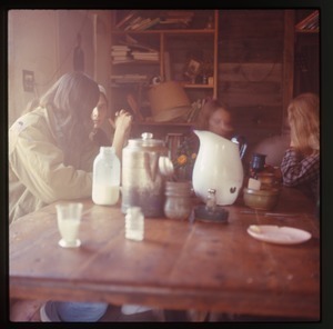 Whit Garberson (left) and others, seated at a table, Montague Farm Commune
