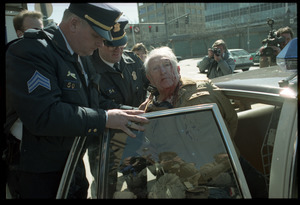 Elderly man with bloodied head (Wilfrid Lapierre) being arrested and put into patrol car by two policemen after protesting the banking crisis