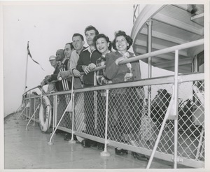 People leaning against rail on boat ride