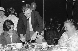 Mayor Raymond L. Flynn cutting an unidentified child's food at an AFL-CIO sponsered meal