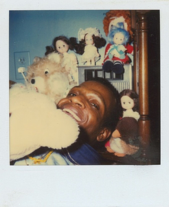 A Photograph of Marsha P. Johnson Smiling With Dolls and Stuffed Animals