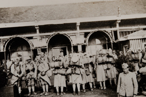 Group of soldiers in full kit standing in front of a canteen