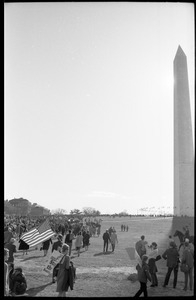 Protesters walking toward the Washington Monument, one with a large American flag: Washington Vietnam March for Peace