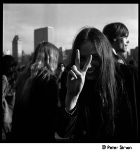 Young woman flashing a peace sign at the Be-in, Central Park, New York City