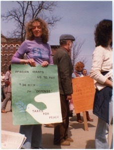 Marion Van Arsdell at an anti-war demonstration, holding a sign reading 'Reagan wants us to pay $34 million for defense -- Taxes for peace'