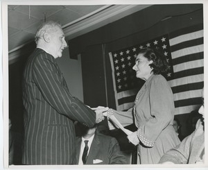 Unidentified staff member handing gift to client on stage at Institute Day