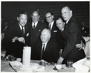 Mayor John F. Collins with Massachusetts Governor John Volpe and four unidentified men cutting cake shaped like the Prudential Tower